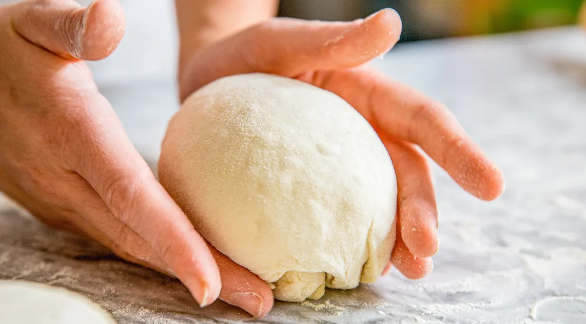 Pizzateig wird in Form gebracht