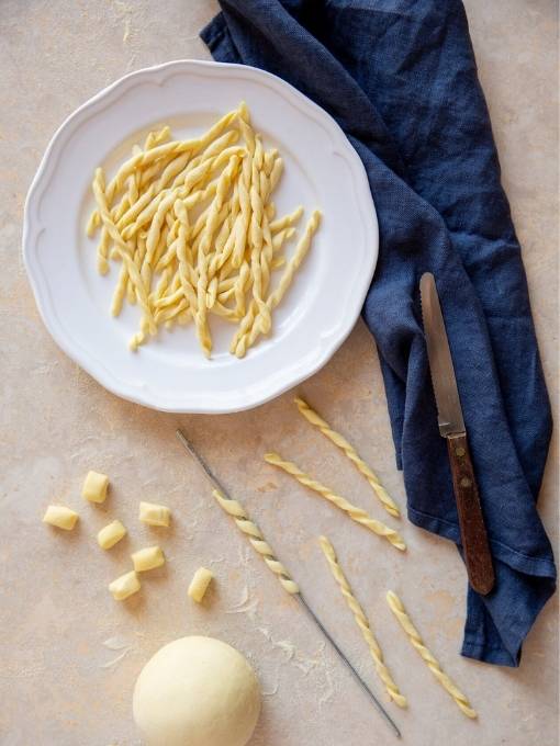 Stadien der Fusilli-Entstehung dekorativ dargestellt - vom Teig zur Nudel