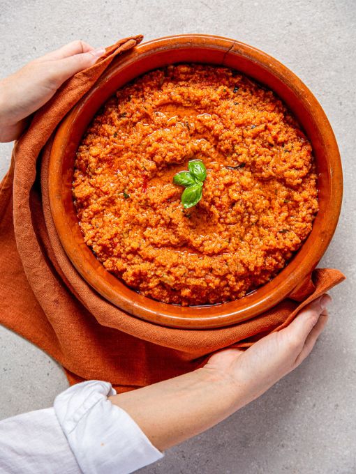 Hände halten eine Schüssel mit Pappa al Pomodoro