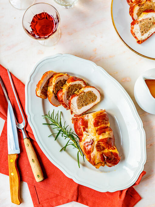 Hühnerbrust im Schinkenmantel auf einem Servierteller
