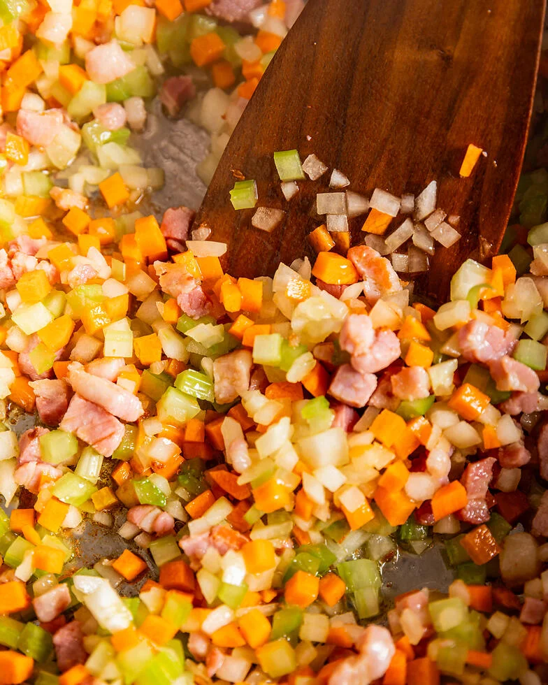 Nahaufnahme Rezept Sofritto im Topf aus Zwiebel-, Sellerie- und Möhrenwürfeln