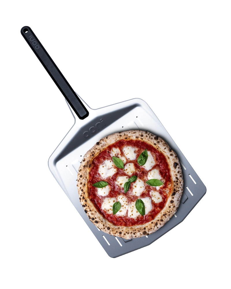 Ooni - Perforierter Pizzaschieber, 35 cm Ooni - Perforierter Pizzaschieber – aufgestellt zur Veranschaulichung der Funktion