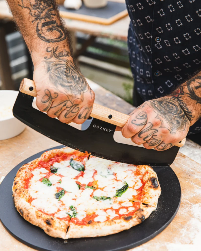 Gozney - Pizzaschneider – mit passenden Accessoires arrangiert
