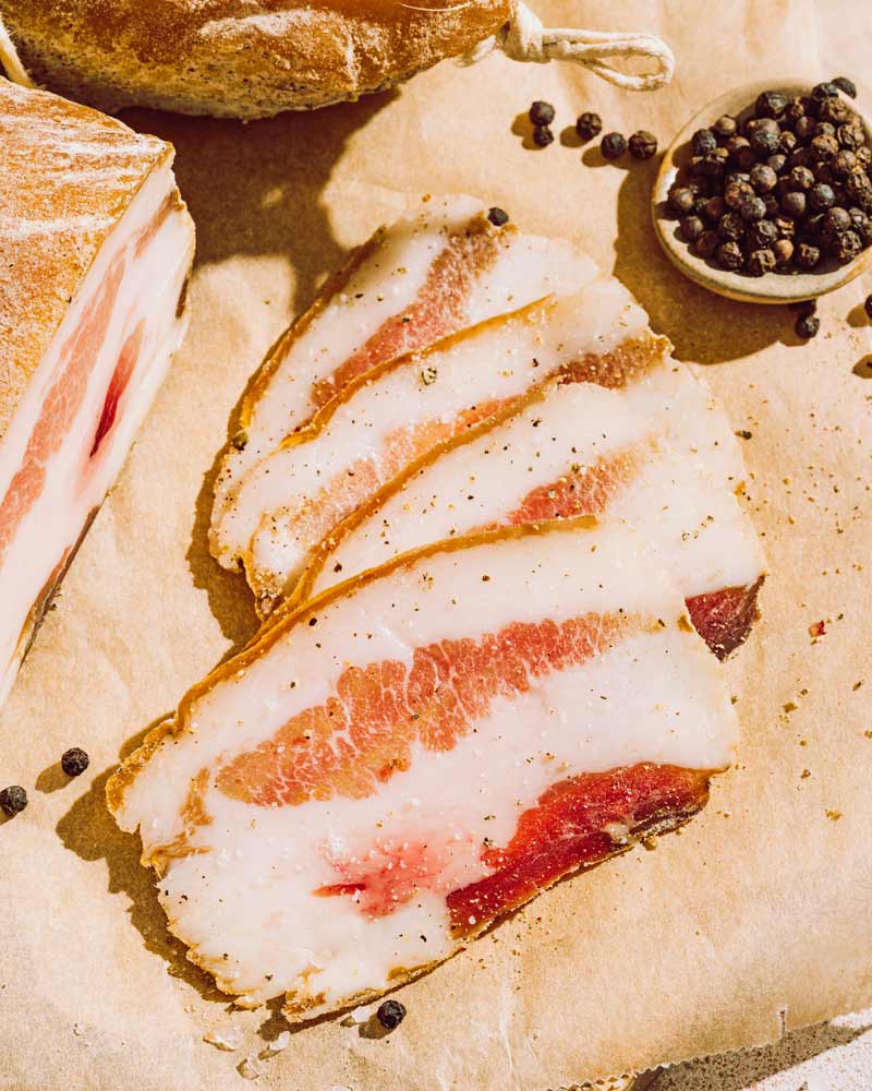 Guanciale - ganzer Backenspeck – mit passenden Accessoires arrangiert